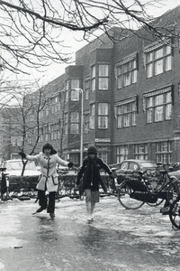 826776 Afbeelding van twee schaatsende meisjes op het bevroren voorterrein van het Diakonessenhuis (Bosboomstraat 1) te ...